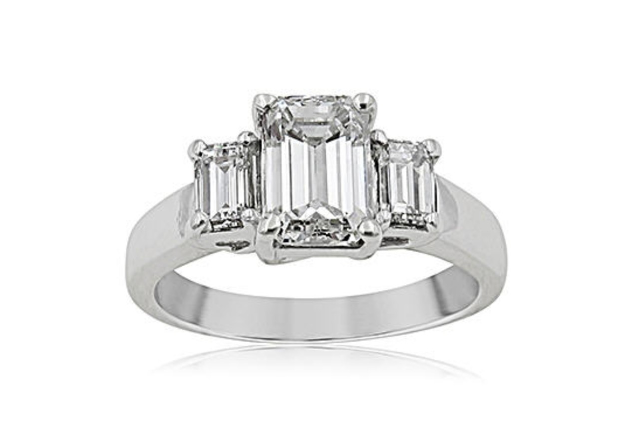 a white gold engagement ring with three emerald cut diamonds