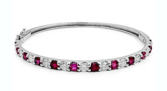 a white gold bangle bracelet featuring rubies and diamonds