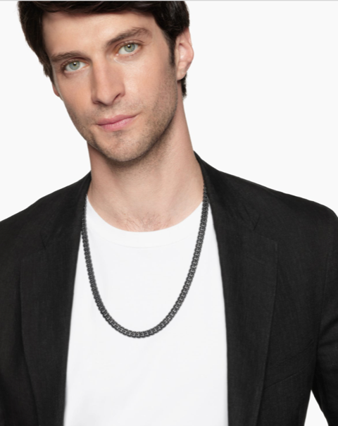 close up image of a man’s neckline wearing a yellow gold chain necklace