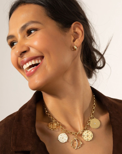 Monica rich Kosann gold medallions on a yellow gold chain necklace in a smiling