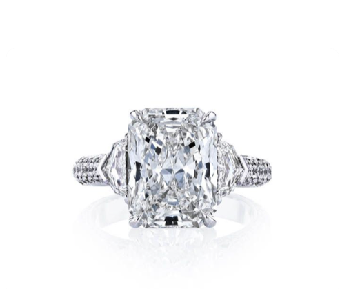 A three-stone ring featuring a radiant cut diamond, accented with two trapezoid diamonds set in platinum