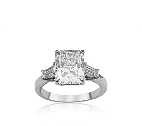 A three stone engagement ring with a large radiant cut center stone featuring a radiant cut center diamond, accented with two tapered baguette diamonds